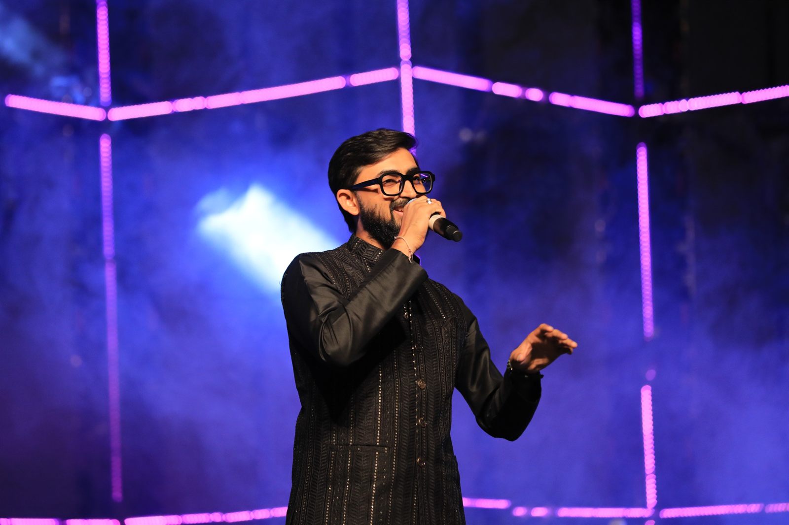 Singer performing under purple stage lights